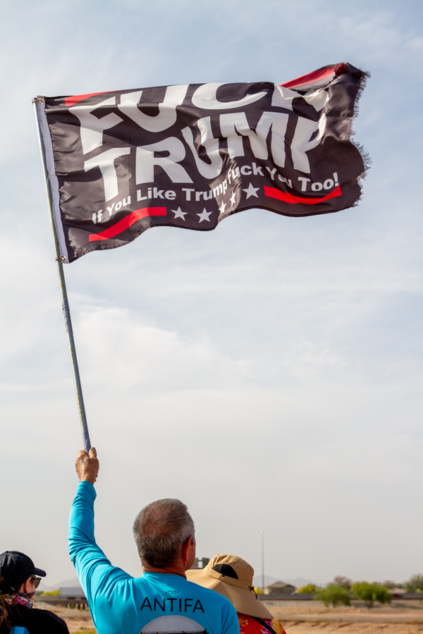 Protester with Antifa shirt holding a black Fuck Trump flag at Goodyear AZ rally