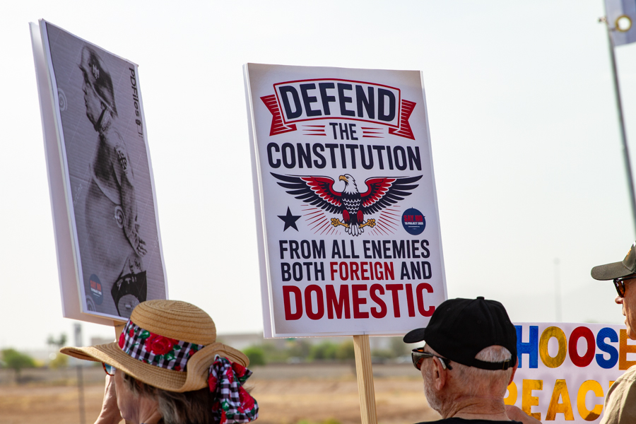 Protesters holding a sign reading Defend the Constitution From All Enemies Both Foreign and Domestic at a Goodyear Arizona rally
