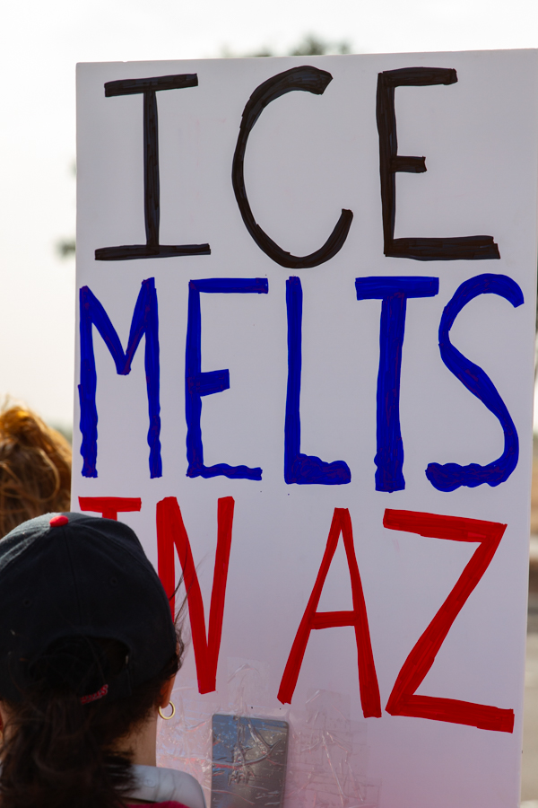 Protester holding a sign reading ICE Melts In AZ at an immigration and political rally in Goodyear Arizona