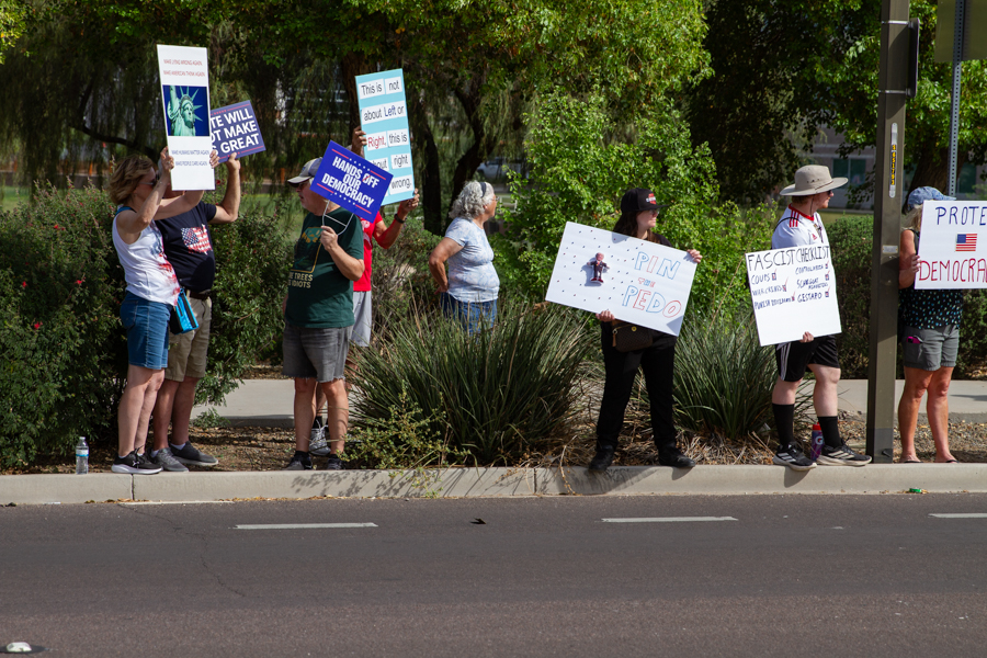 Protesters holding a Fascist Checklist sign and Hands Off Our Democracy sign at a Goodyear Arizona demonstration