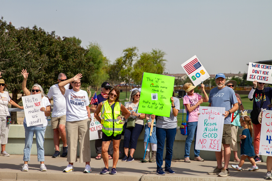 Protesters holding Justice for Renee Nicole and green satirical John toilet signs at a Goodyear Arizona rally