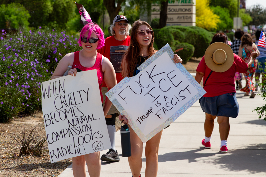 Protesters holding signs reading When Cruelty Becomes Normal Compassion Looks Radical and Fuck ICE Trump Is A Fascist at a Goodyear Arizona rally