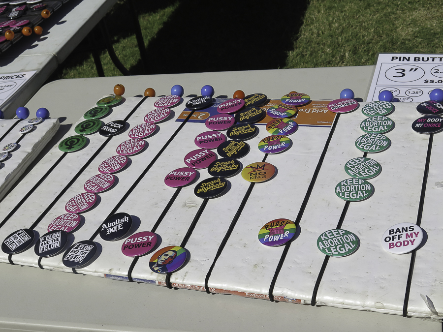 Protest buttons and pins at Phoenix No Kings 2.0 rally reading Keep Abortion Legal, Smash Oligarchy, Pussy Power, and No Kings