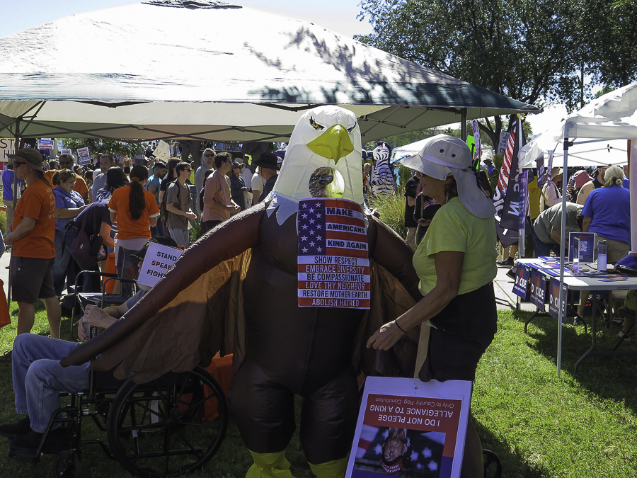 Activists at Phoenix No Kings 2.0 rally featuring an inflatable bald eagle costume with progressive slogans and an anti-Trump I Do Not Pledge Allegiance To A King sign