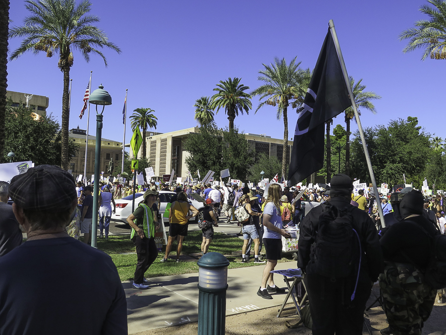 No Kings 2.0 protest crowd and peace flag at the Arizona State Capitol building plaza in Phoenix